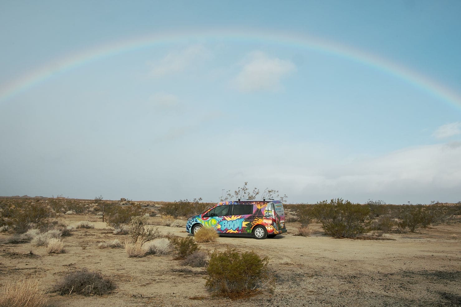 escape campervan rental under a rainbow